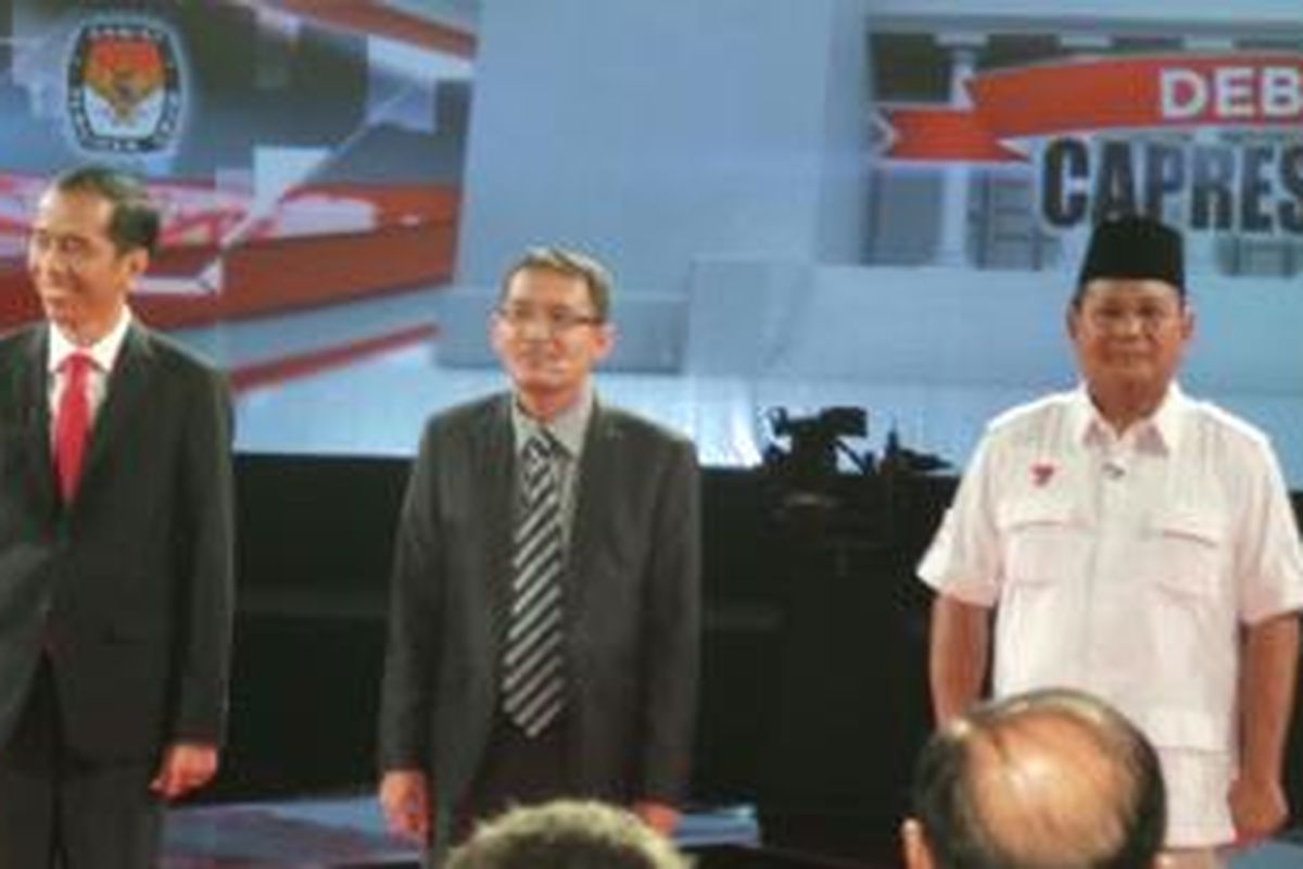 Capres nomor urut satu dan dua Joko Widodo dan Prabowo Subianto mengapit Moderator Prof. Ahmad Erani Yustika dalam debat kandidat di Jakarta selatan Minggu (15/6/2014) malam.