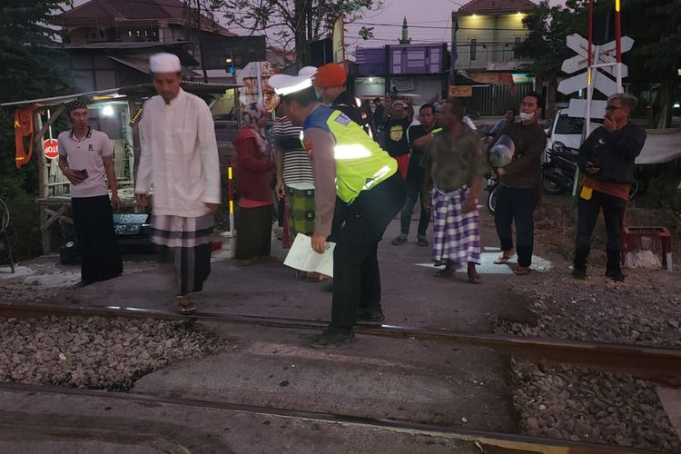 Polisi saat meminta keterangan warga yang melihat insiden mobil Toyota Avanza tertabrak kereta api di perlintasan sebidang JPL 303 KM 180 Desa Surabayan, Kecamatan Sukodadi, Lamongan, Jawa Timur, Rabu (18/10/2023).