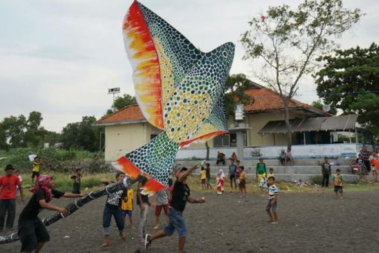 Peserta Festival Layang Layang sedang menerbangkan layang-layang di Pantai Boom, Banyuwangi, Jawa Timur,  Minggu (7/8/2016).