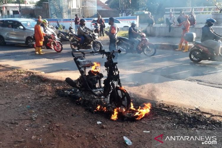 Jalan Raya DI Panjaitan Jakarta Timur mengalami kemacetan akibat sejumlah pengendara memperlambat laju kendaraan untuk menyaksikan sepeda motor yang terbakar akibat korsleting listrik, Jumat (28/8/2020). 