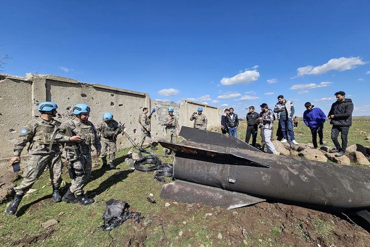 Pasukan penjaga perdamaian PBB dan warga sipil melihat-lihat puing roket Iran yang dicegat Israel di Suriah selatan, tepatnya di Quneitra, dekat Dataran Tinggi Golan, Sabtu (28/2/2026). Serangan Israel-Amerika Serikat ke Iran berujung konflik luas di Timur Tengah.