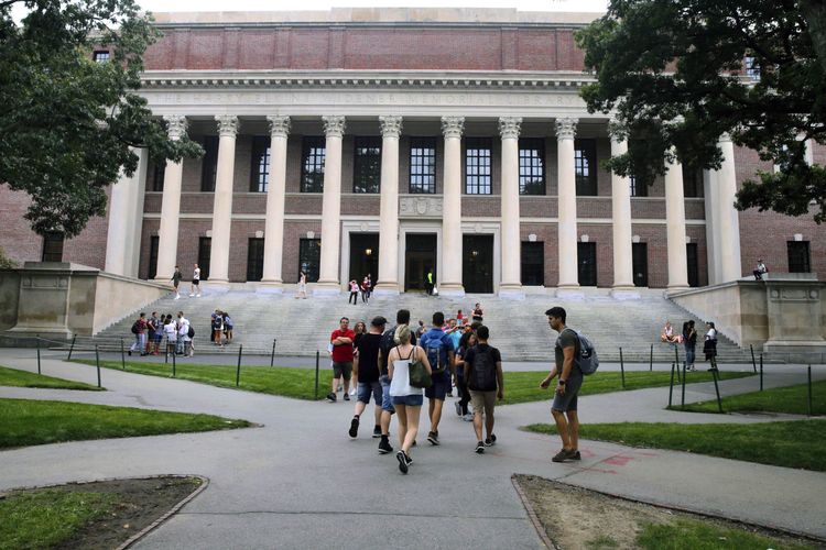 Para pelajar sedang berjalan dekat Perpustakaan Widener di halaman Universitas Harvard di Cambridge.