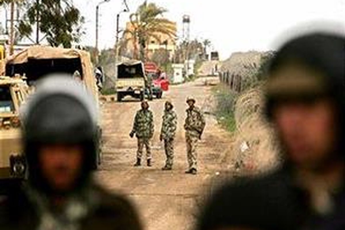 Polisi Mesir memonitor warga Palestina yang menyeberang di antara perbatasan Mesir dan Rafah, Jalur Gaza bagian selatan. 