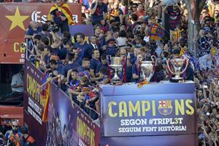 Para pemain Barcelona diarak memakai bus atap terbuka saat merayakan keberhasilan meraih treble winners, Minggu (7/6/2015). 