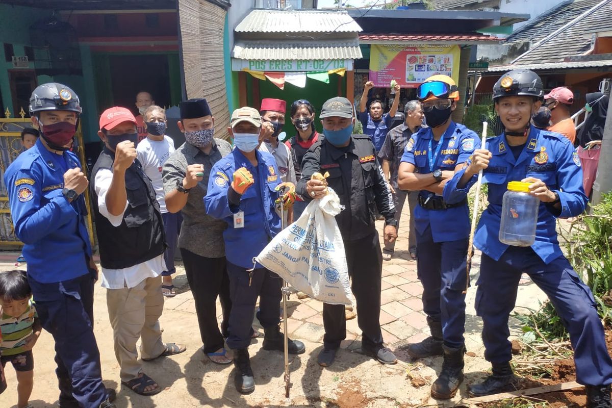 Petugas Dinas Pemadam Kebakaran dan Penyelamatan beserta Tagana (Taruna Siaga Bencana) Kota Depok mengevakuasi 3 ekor ular kobra jawa di permukiman penduduk di Cilodong, Depok, Senin (5/10/2020)