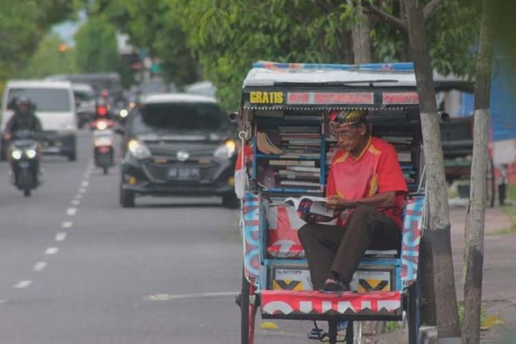 Sutopo biasa menunggu penumpang atau peminjam buku dari becaknya yang diparkir di Jalan Tentara Pelajar, Kota Yogyakarta.