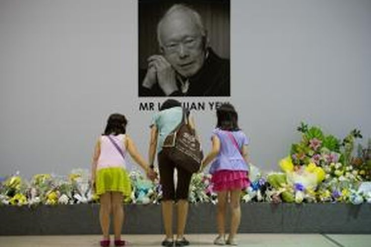 Seorang warga Singapura dan kedua anaknya memberikan hormat di hadapan foto mendiang bapak bangsa Lee Kuan Yew yang meninggal dunia pada Senin (23/3/2015) dalam usia 91 tahun.