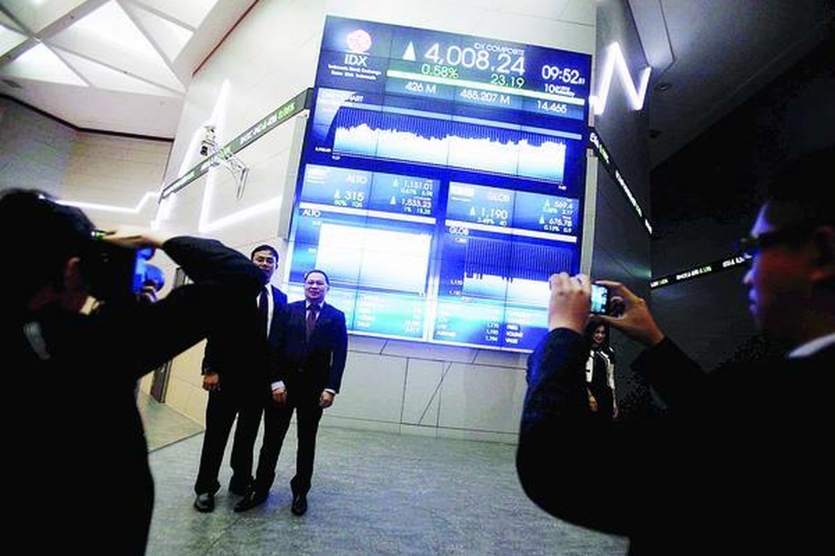 Tamu undangan berfoto dengan latar belakang monitor pencatatan perdana dua perusahaan sekaligus, yaitu PT Tri Banyan Tirta Tbk dan PT Global Teleshop Tbk, di Bursa Efek Indonesia, Jakarta, Selasa (10/7). Perusahaan berlomba-lomba masuk bursa guna mendapatkan tambahan modal melalui penjualan saham untuk pengembangan bisnis.