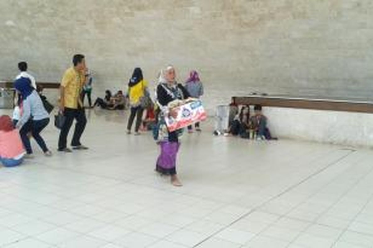 Seorang PKL menjajakan barang dagangan dengan berkeliling tugu Monas, Minggu (20/4/2014).