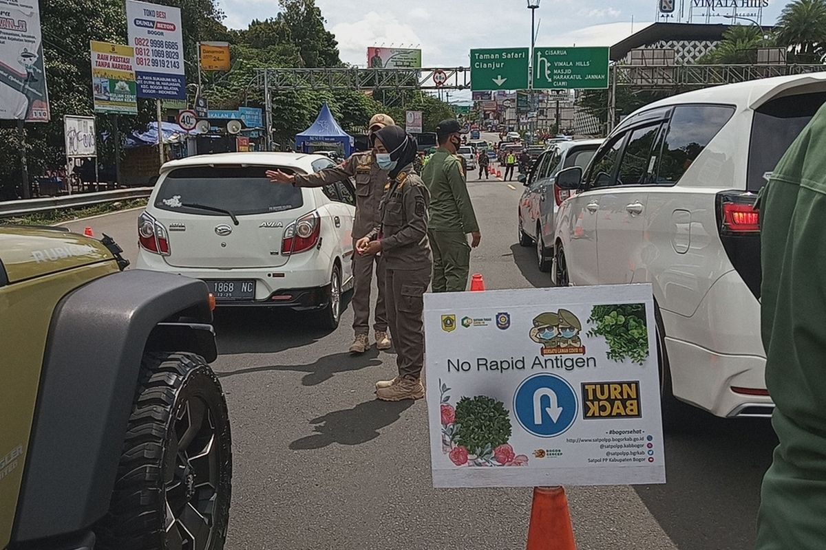 Sejumlah petugas sedang memeriksa surat rapid antigen sebagai syarat untuk ke Puncak Bogor di Simpang Gadog, Kabupaten Bogor, Jawa Barat, Jumat (12/2/2021)