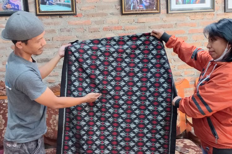 Erwin, perajin kain tenun ikat Bandar Kidul Kota Kediri, Jawa Timur, saat melayani pembeli yang datang ke tempat usahanya, Sabtu (22/10/2022).