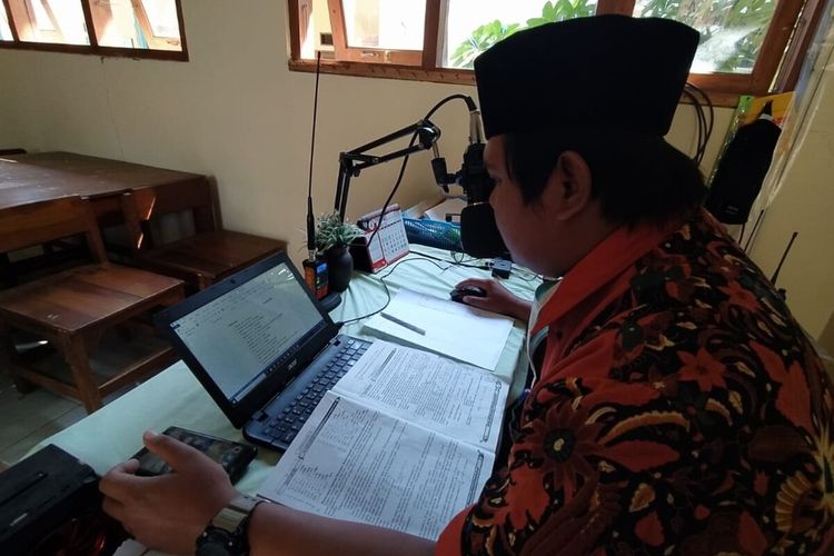 Wali kelas VI B SDN Mojo, Sigit Pambudi memberikan pembelajaran jarak jauh kepada siswanya menggunakan HT di SDN Mojo, Solo, Jawa Tengah, Rabu (19/8/2020).