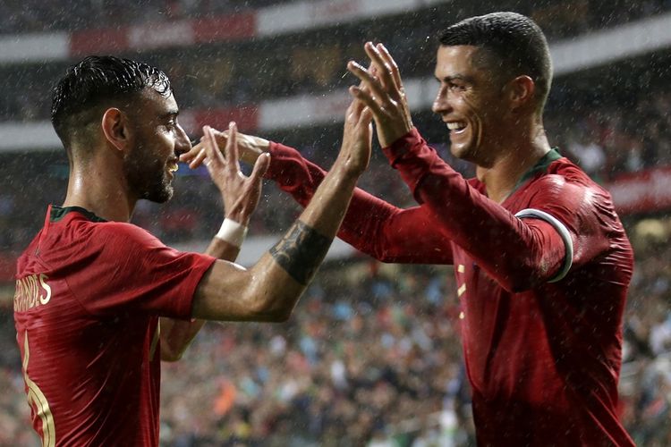 Bruno Fernandes (kiri) dan Cristiano Ronaldo (kanan) merayakan gol pada pertandingan persahabatan antara Portugal dan Aljazair, 7 Juni 2018 di Stadion Luz, Lisbon. 