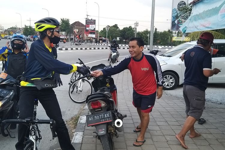 BAGI MASKER—Bupati Madiun, Ahmad Dawami membagi masker bagi warga saat bersepeda keliling dari desa ke desa, Jumat (28/8/2020)