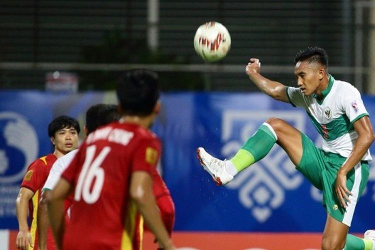 Bek timnas Indonesia, Rizky Ridho Ramadhani (kanan), melompat menendang bola saat tampil dalam pertandingan Piala AFF 2020 antara Indonesia vs Vietnam di Stadion Bishan, Rabu (15/12/2021).  