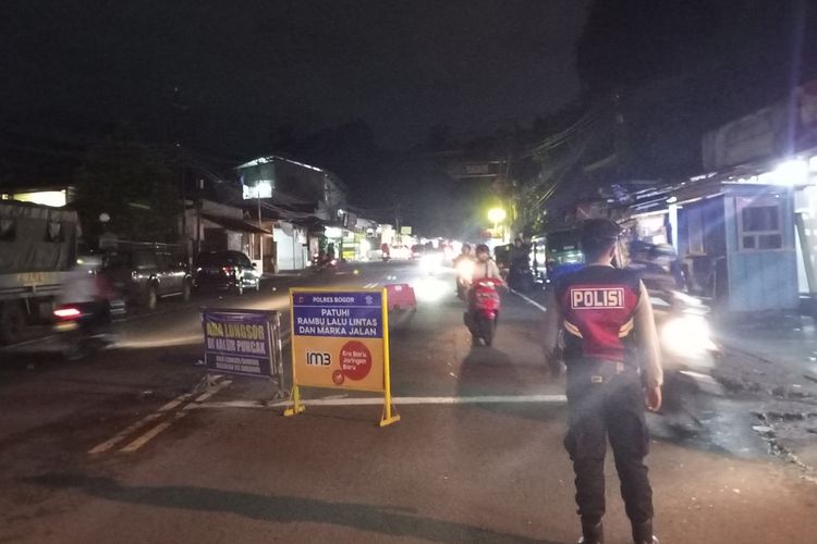 Petugas kepolisian sedang menutup ruas jalan yang menuju ke atas menggunakan water barrier di pintu Exit GT Ciawi atau sekitaran Pospol Simpang Gadog, Kabupaten Bogor, Jawa Barat, Sabtu (31/12/2022) pukul 23.00 WIB.