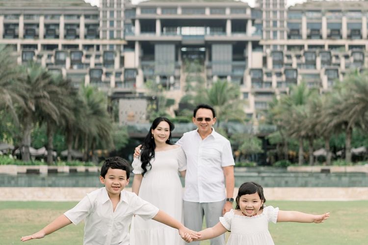 Puput Nastiti Devi tampil anggun dengan long dress putih, makeup natural, dan rambut wavy saat foto kehamilan anak ketiga bersama keluarga.