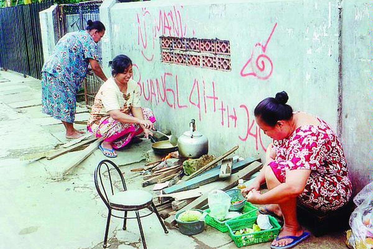 Akibat kelangkaan elpiji, kaum ibu di Kampung Beting, Tugu Utara, Kecamatan Koja, Jakarta Utara, memasak dengan menggunakan kayu bakar, Selasa (16/12).  