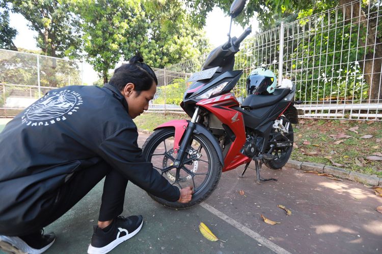 Salah satu tips aman parkir motor selama ditinggal mudik, memastikan tekanan angin ban sesuai ketentuan.