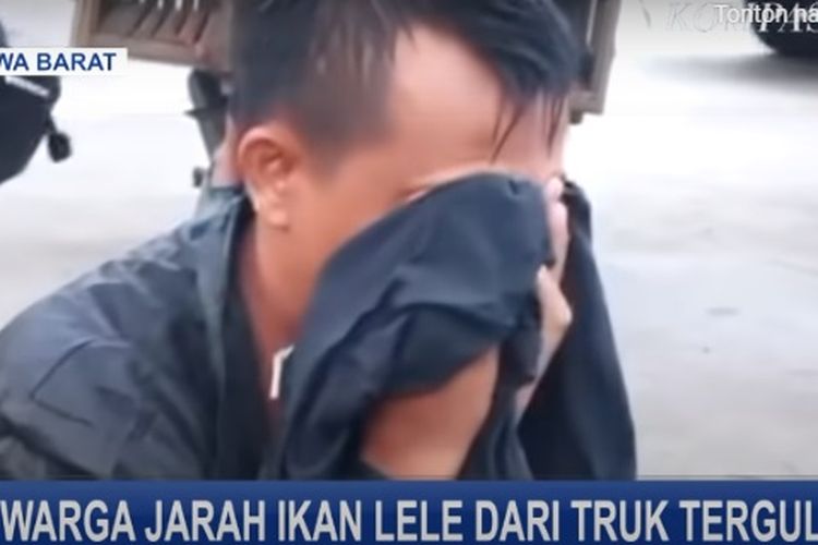 Edi, pengemudi truk lele hanya bisa menangis di pinggir sawah melihat lele yang dibawanya dijarah oleh warga.
