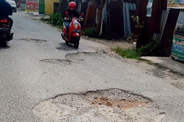 Kondisi Jalan Bustamam, Pasar 10 Bandar Klipa, Kecamatan Percutseituan, Kabupaten Deliserdang, Sumatra Utara,  berlubang di sana-sini, Rabu (22/2/2023).