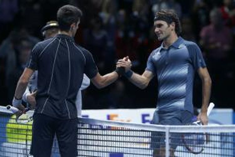 Petenis Serbia, Novak Djokovic (kiri) bersalaman dengan petenis Swiss, Roger Federer, setelah laga pada babak round robin ATP World Tour Finals di London, Rabu (13/11/2013). Djokovic menang 6-4, 6-7(2), 6-2.