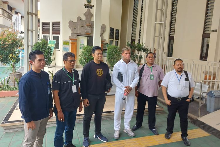 Adam Alexander (29), mengenakan pakaian serba putih saat menjalani sidang Tipiring di PN Denpasar dalam kasus penganiayaan ringan terhadap polisi, pada Jumat (22/9/2023).