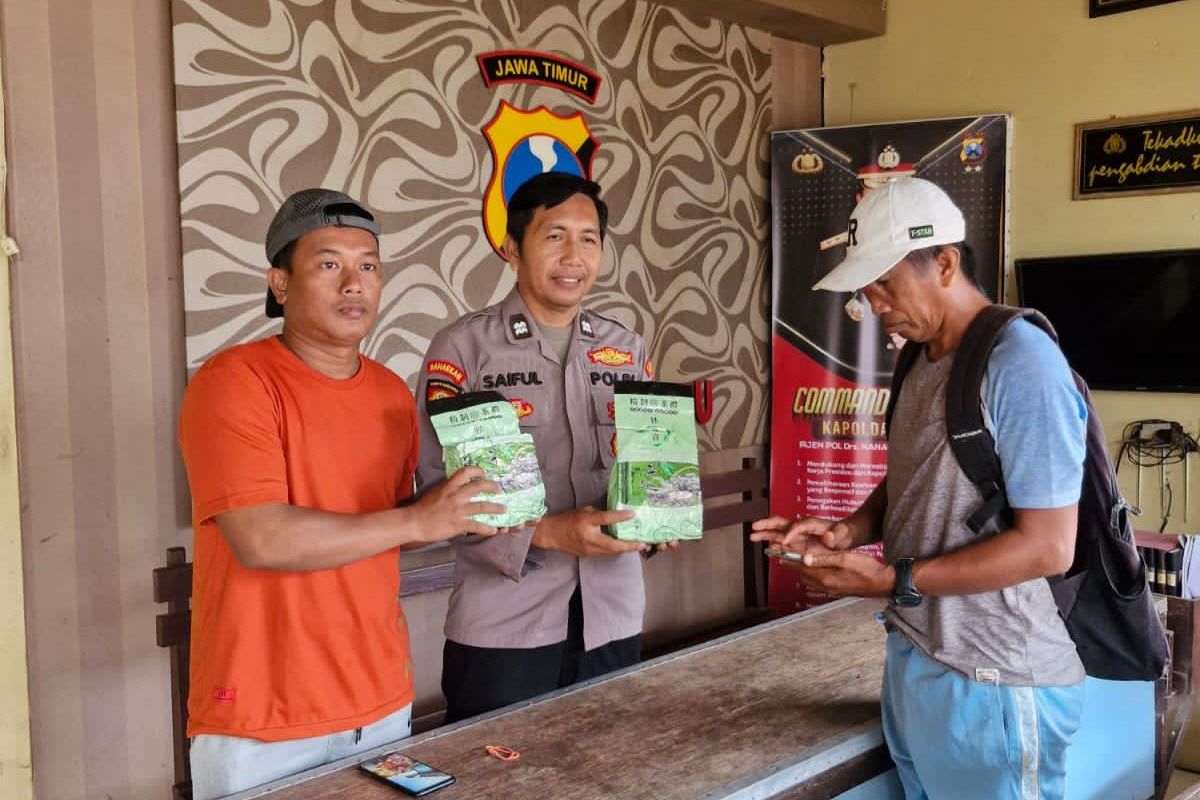 Saat Zakariya mengantar Faqih, seorang warga Dusun Ambulung, Desa Sukajeruk, Kecamatan Masalembu, Kabupaten Sumenep, Jawa Timur, mengembalikan 2 kilogram sabu ke Polsek Masalembu, Minggu (1/6/2025). 
