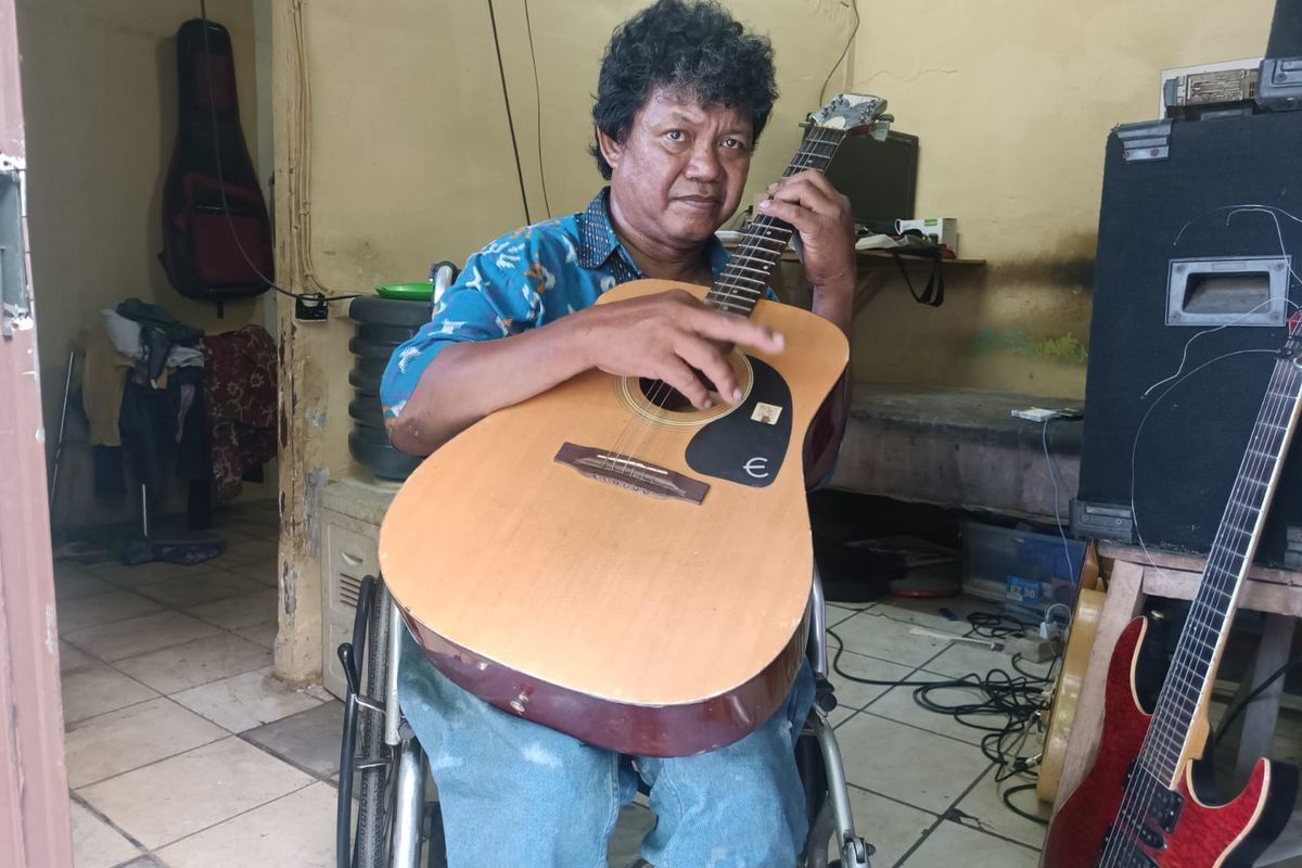 Ivan Rivani (51), penyandang tuna daksa yang membuka les gitar keliling, di kediamannya di Cipinang, Pulogadung, Jakarta Timur, Jumat (20/10/2023).