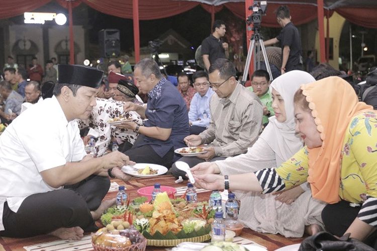 Wali Kota Semarang Hendrar Prihadi memakan nasi tumpeng Kembul Bujono dalam acara peringatan 1 Muharam atau Tahun Baru Islam di Balaikota Semarang, Senin (10/9/2018) malam. 
