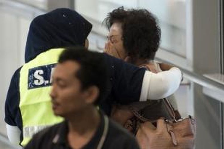 Keluarga penumpang Malaysia Airlines MH17 dihibur petugas di Bandara Kuala Lumpur (KLIA) pada Jumat (18/7/2014).