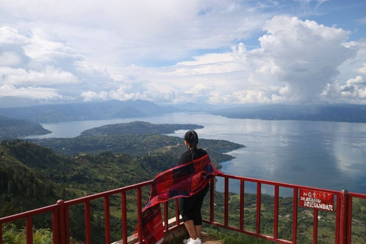 Pengunjung sedang menikmati pemandangan Danau Toba di Huta Ginjang di Kabupaten Tapanuli Utara
