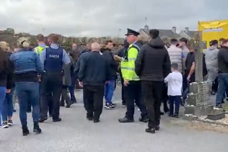 Polisi berjaga di Pemakaman Tuam, Galway, Irlandia, setelah muncul perkelahian antara dua pelayat. Perkelahiannya dilaporkan begitu brutal sehingga pelayat terpaksa menurunkan peti mait begitu saja.