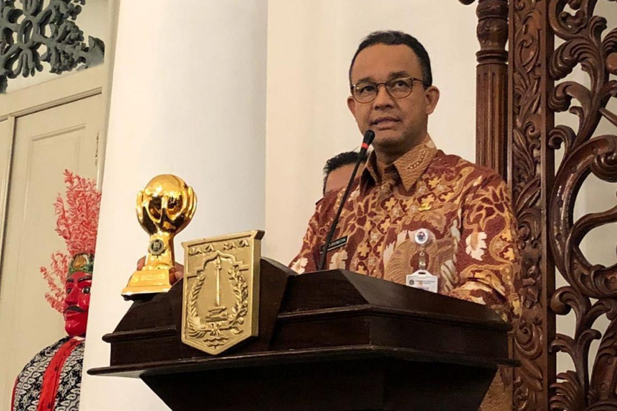 Gubernur DKI Jakarta Anies Baswedan menunjukkan piala Universal Health Coverage (UHC) JKN (Jaminan Kesehatan Nasional) - KIS (Kartu Indonesia Sehat) Award di Balai Kota, Kamis (24/5/2018).