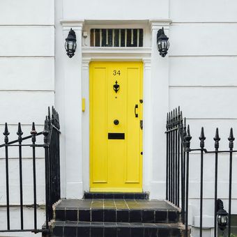 Ilustrasi pintu depan rumah berwarna kuning.
