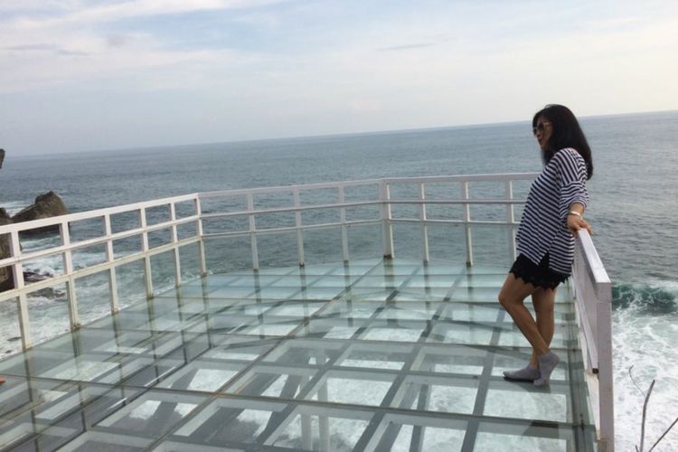 Visitors enjoy the glass terrace on Nguluran Beach in Gunungkidul, Yogyakarta.