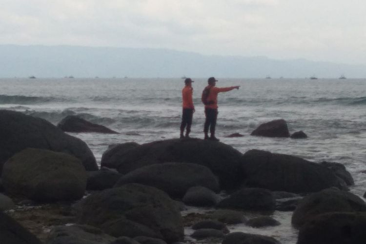 Dua anggota tim SAR memantau dari tepi pantau dalam operasi pencarian anak di laut Sukabumi, Jawa Barat, Minggu (31/10/2021).
