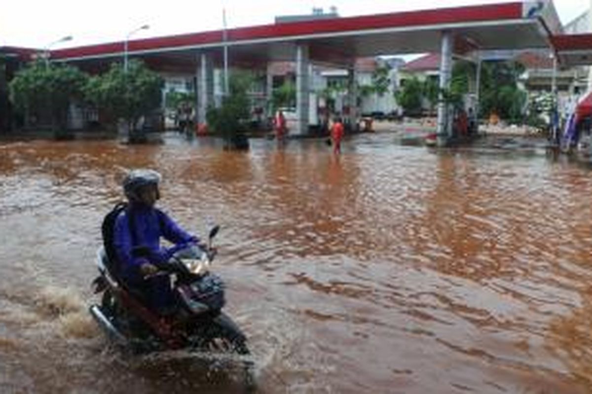 Banjir yang merendam kawasan Penjaringan, Jakarta Utara ikut melumpuhkan aktivitas bisnis setempat, Selasa (9/2/2015). Nampak jalan di depan salah satu SPBU di jalan itu, ikut kebanjiran.