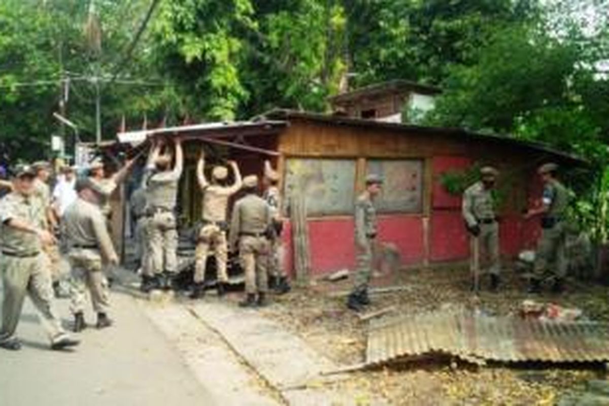 Sedikitnya 28 bangunan liar semi permanen yang berada di bantaran kali dan diatas saluran air di Kelurahan Depok Jaya, Pancoran Mas, ditertibkan petugas Satpol Pamong Praja (Satpol PP) Kota Depok, Kamis (21/8/2014) siang. Selain menempati lahan yang bukan peruntukkannya, kehadiran sejumlah bangunan liar yang digunakan untuk berdagang ini menjadi salah satu penyebab banjir. 