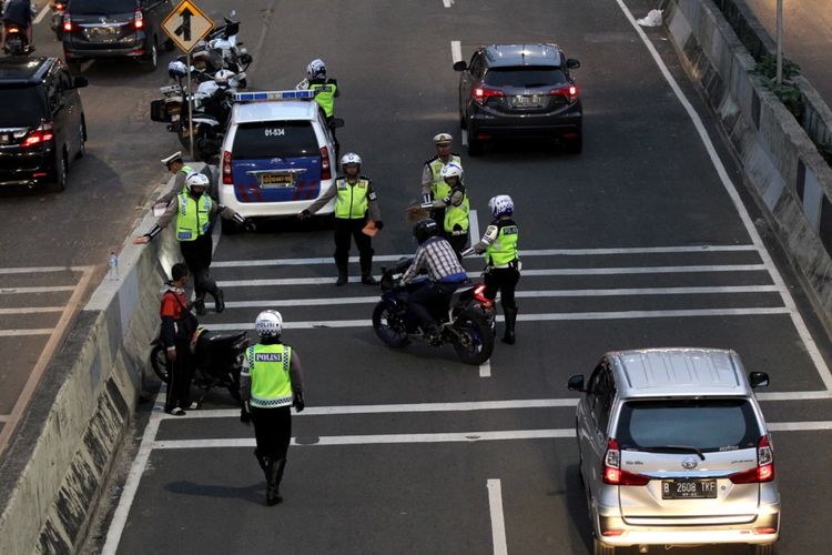 Polisi melakukan razia sepeda motor yang nekat menerobos ke jalan layang non tol (JLNT) Kampung Melayu-Tanah Abang, Jakarta, Selasa (25/7/2017). Pengendara motor masih nekat memasuki dan melintasi JLNT tersebut baik dari arah Tanah Abang maupun Kampung Melayu. KOMPAS IMAGES/KRISTIANTO PURNOMO