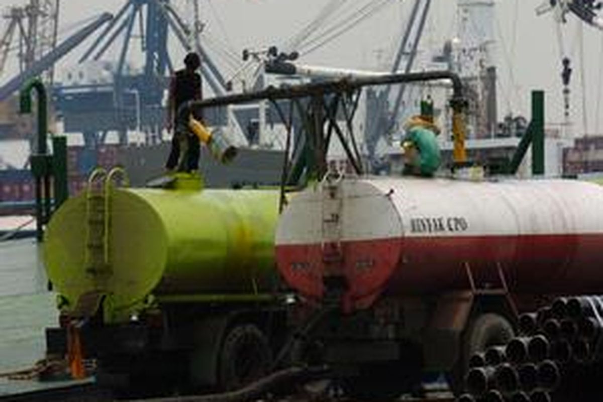Dua awak truk sedang mengisi minyak sawit mentah (crude palm oil/CPO) di Pelabuhan Tanjung Priok, Jakarta, Minggu (23/10) lalu.
