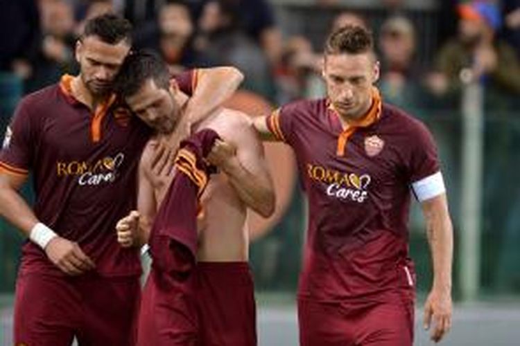 Pemain AS Roma, Miralem Pjanic, membuka bajunya seusai mencetak gol ke gawang AC Milan dalam lanjutan Serie-A, Jumat (25/4/2014). 