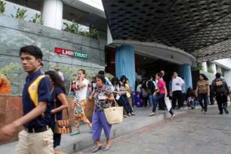 Para karyawan keluar gedung kantor setelah diguncang gempa di Medan, Sumatera Utara, 2 Juli 2013. Gempa berkekuatan 6.2 SR di Aceh, menghancurkan rumah dan mengakibatkan tanah longsor. Tujuh orang tewas dan puluhan terluka.