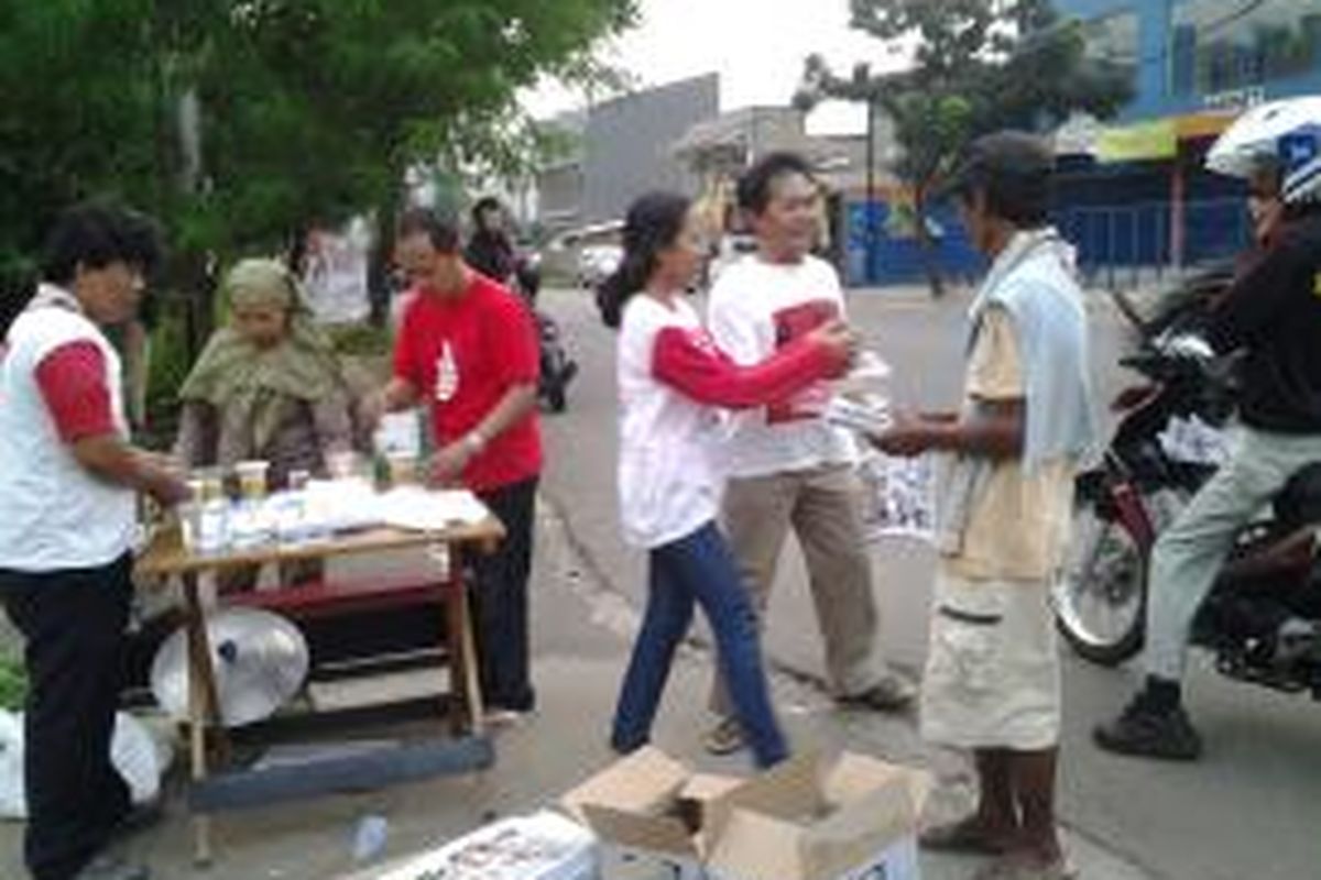 Rebo bersama relawan Almisbat lainnya membagikan kolak gratis dan Tabloid Obor Rahmatin Lil Alamin di Jalan Deplu Raya, Bintaro, Jakarta Selatan, Senin (30/6/2014).