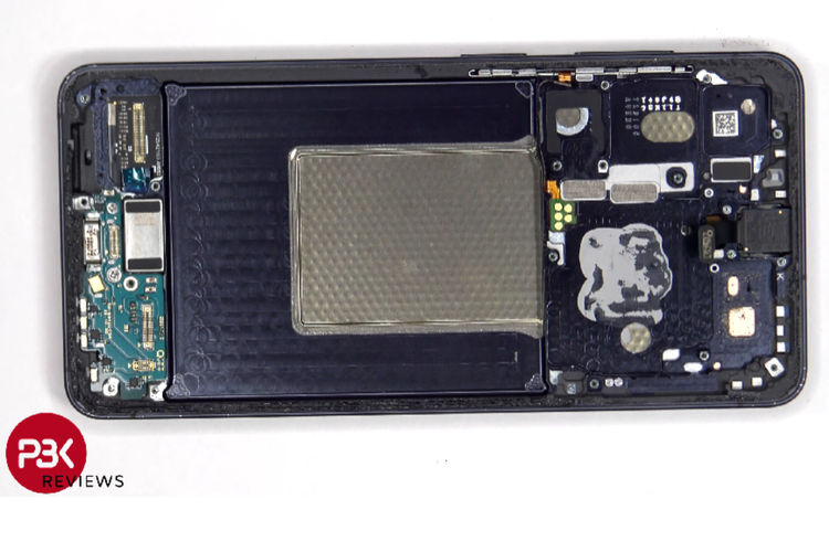 Bagian dalam Samsung Galaxy S26 setelah penutup belakang dilepas. Terlihat susunan komponen yang rapi, termasuk area baterai dan modul utama di sisi kanan. 