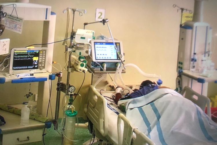 Pasien melakukan proning position mandiri setelah diajarkan oleh Dr SpKFR di ruang isolasi biasa dengan ventilator di RSUP Persahabatan.