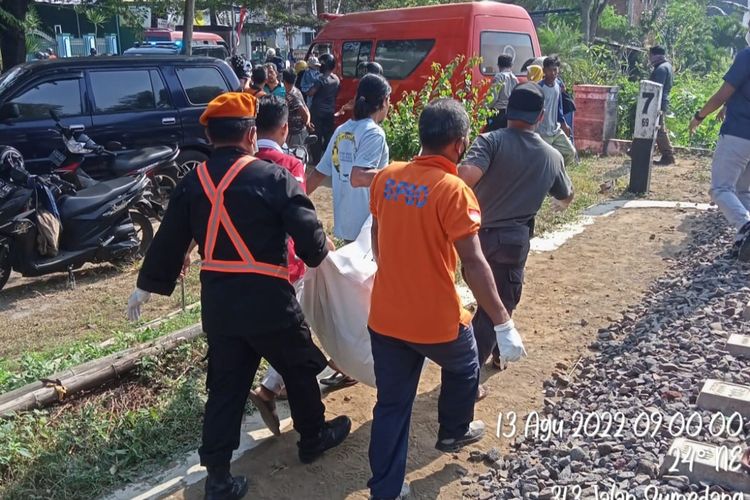 Petugas saat mengevakuasi warga Kelurahan Cempokomulyo, Kecamatan Kepanjen, Kabupaten Malang, Sumarlin yang tewas akibat tertabrak Kereta Api Penataran Blitar Malang, Sabtu (13/8/2022).