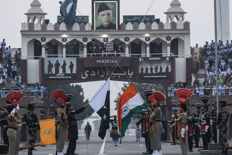 Pasukan Keamanan Perbatasan India dan Penjaga Pakistan (berbaju hitam) menurunkan bendera masing-masing di perbatasan Wagah-Attari pada 15 November 2021.
