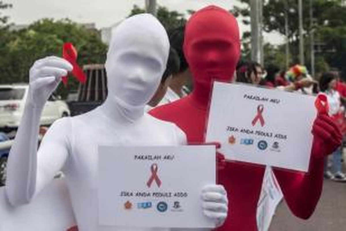 Aktivis membawa pita merah dalam kampanye Hari AIDS Sedunia, di Surabaya, Senin (1/12/2014). Sekitar 45.000 kasus HIV/AIDS terjadi di Indonesia sepanjang 2013 dan 14.400 kematian di tahun yang sama.