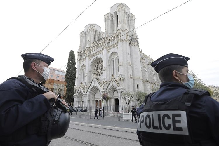 Police officers stand guard near Notre Dame church in Nice, southern France, Thursday, Oct. 29, 2020. An attacker armed with a knife killed at least three people at a church in the Mediterranean city of Nice, prompting the prime minister to announce that France was raising its security alert status to the highest level. It was the third attack in two months in France amid a growing furor in the Muslim world over caricatures of the Prophet Muhammad that were re-published by the satirical newspaper Charlie Hebdo. (Eric Gaillard/Pool via AP)